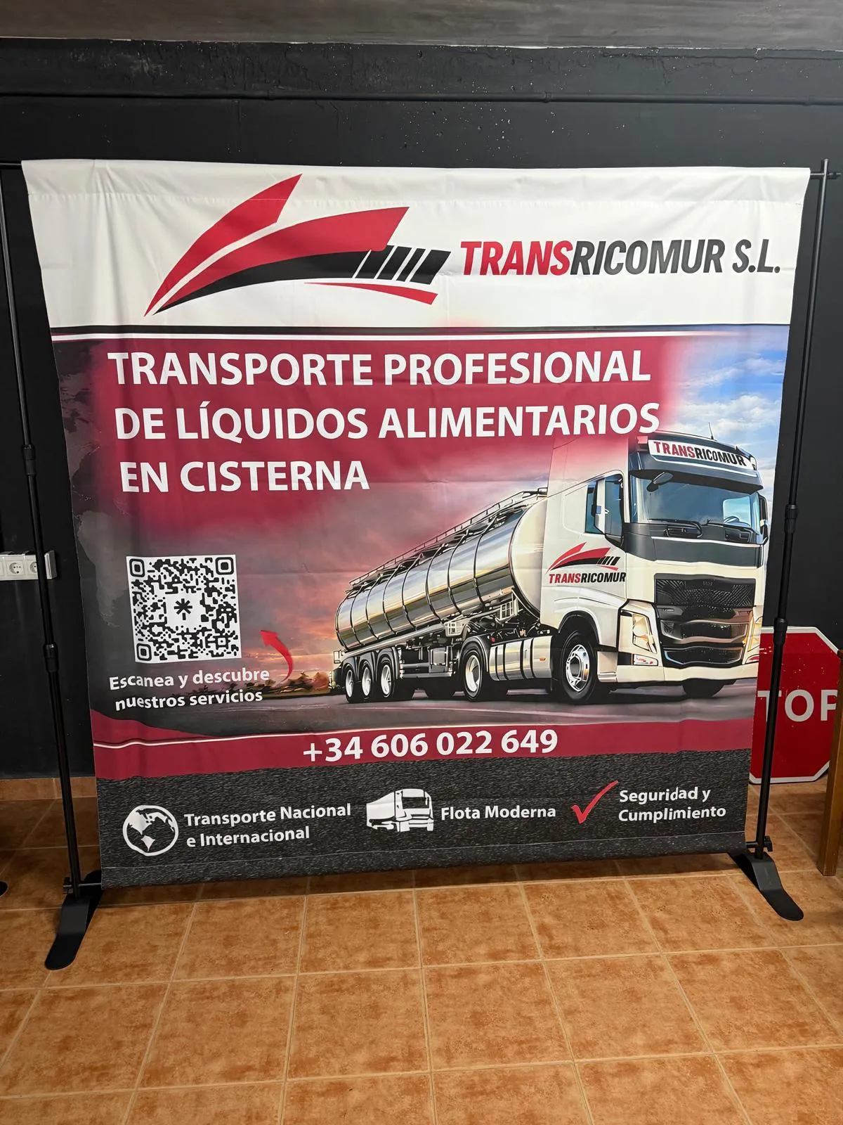 Lona publicitaria de TransRicomur S.L. con imagen de camión cisterna, montada sobre estructura tensora